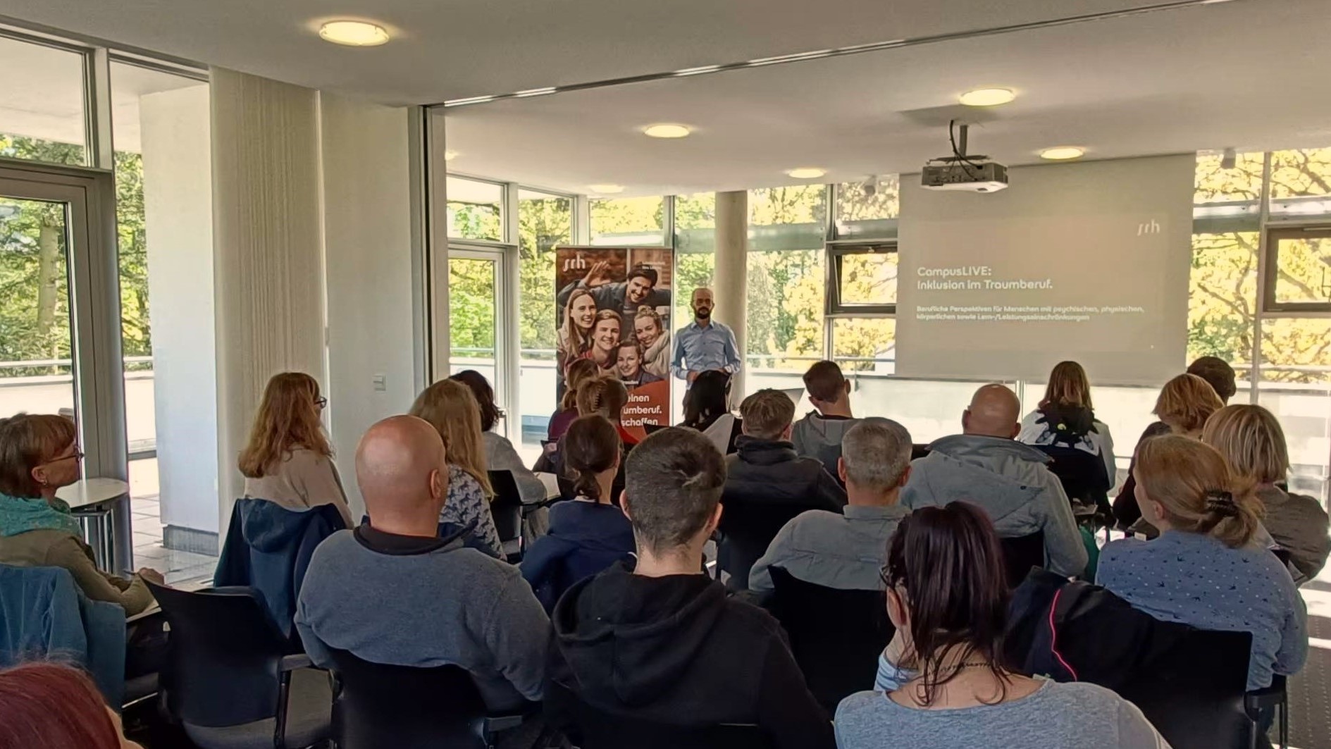 Eine Gruppe von Menschen hört einem Redner in einem Konferenzraum zu.
