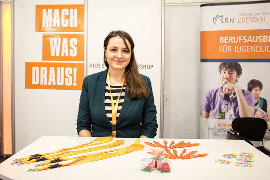Junge Frau am Messestand des SRH BBW