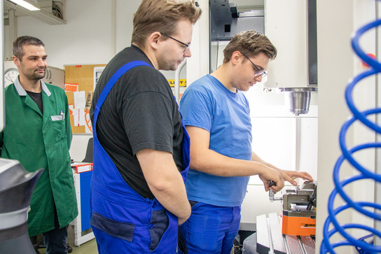 Justin Märten (rechts) und Nick Krieger (links im Bild) aus dem vierten Ausbildungsjahr zum Fachpraktiker für Zerspanungsmechanik stellten mit Gästen Kugelschreiber her.