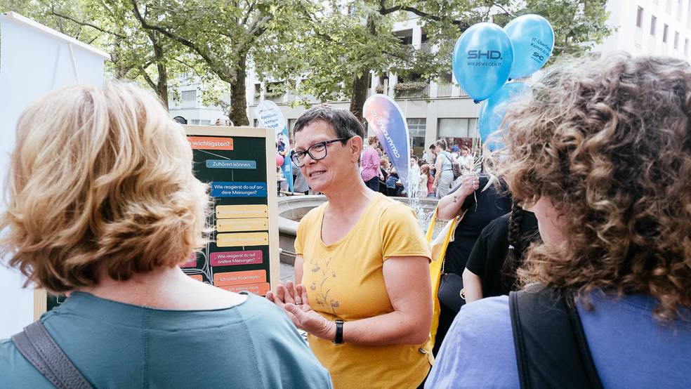 SRH-Mitarbeiterin beim Gespräch mit Besuchern